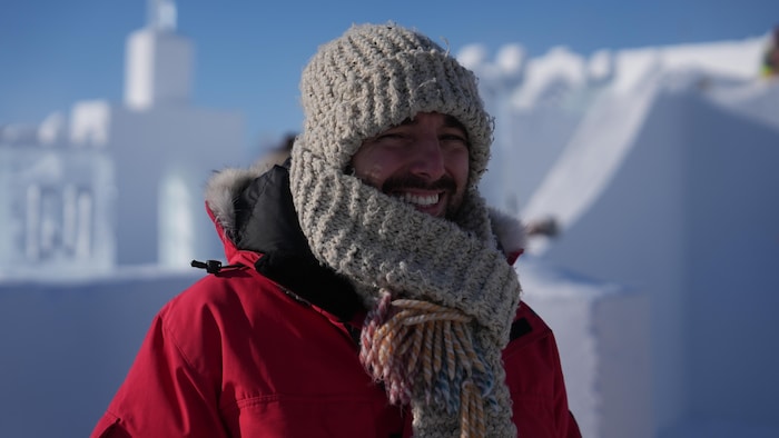 Un homme équipé d'une grosse tuque et d'une grosse écharpe.