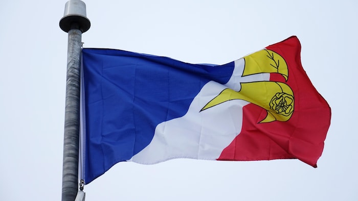 Le drapeau francophone de Terre-Neuve-et-Labrador flotte dans le vent.