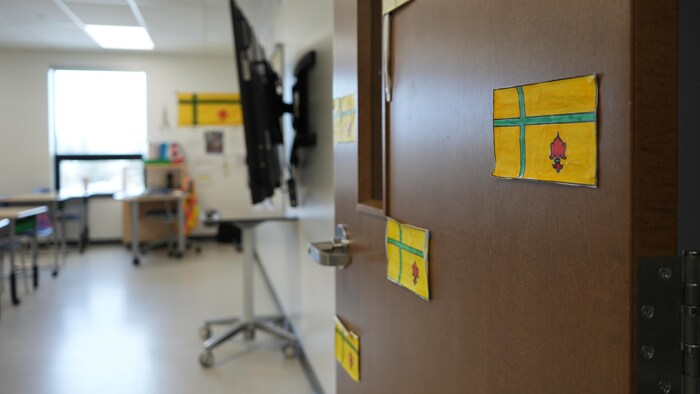Des drapeaux fransaskois sur une porte de classe à l'École du Parc de Regina, en Saskatchewan, le 20 mars 2026.