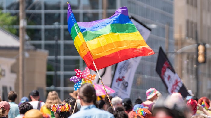 Une personne porte un drapeau LGBT lors du défilé de la Fierté à Saskatoon, en Saskatchewan, le 18 juin 2022.