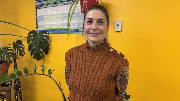 Une femme se tient devant un tableau de sensibilisation aux drogues.
