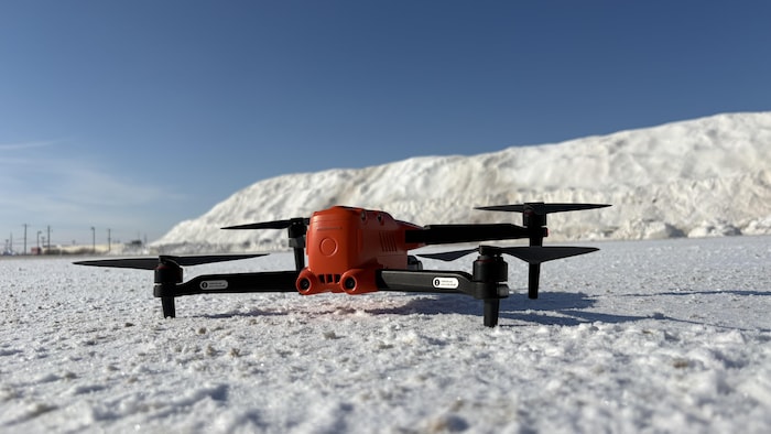 Un drone est posé au sol en hiver.