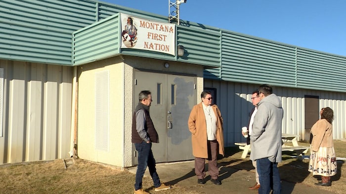 Plusieurs membres du conseil tribal de la Première Nation Montana dont le chef Ralph Cattleman devant un bâtiment de la réserve.