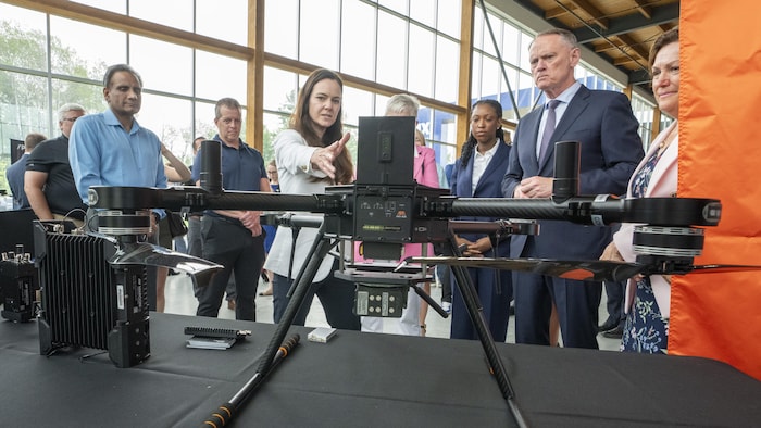 Des personnes regardent un drone.