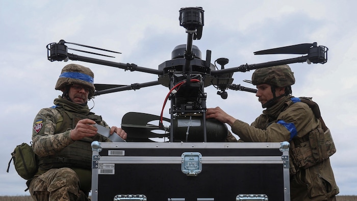 Des soldats ukrainiens montent une bombe sur un drone de combat avant de le lancer à la recherche de positions ou de véhicules russe.