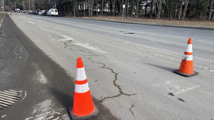 Rue Robert-Bernard, deux cônes orange sont disposés à la ligne d'arrêt.