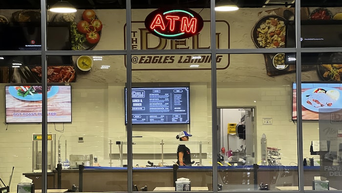 A waitress behind the counter of a restaurant at a truck stop.