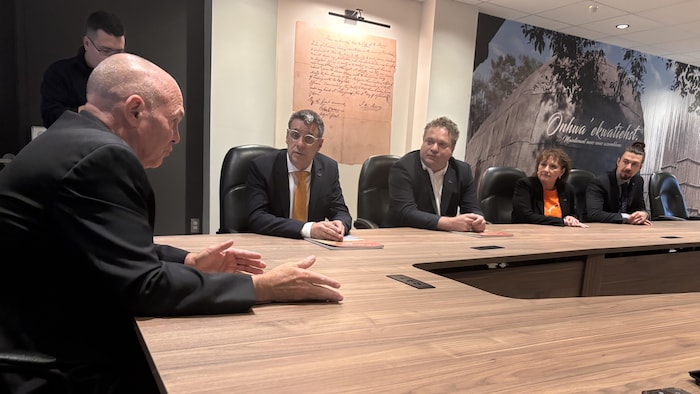 Éric Duhaime et Pierre Picard discutent, assis à une grande table.