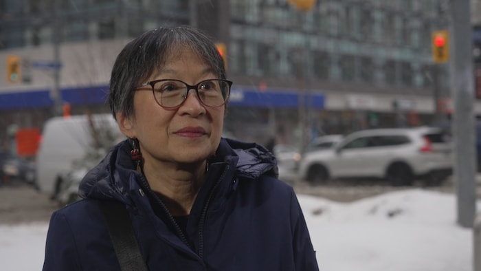 Julie Jai devant la rue Dundas Ouest, à Toronto.