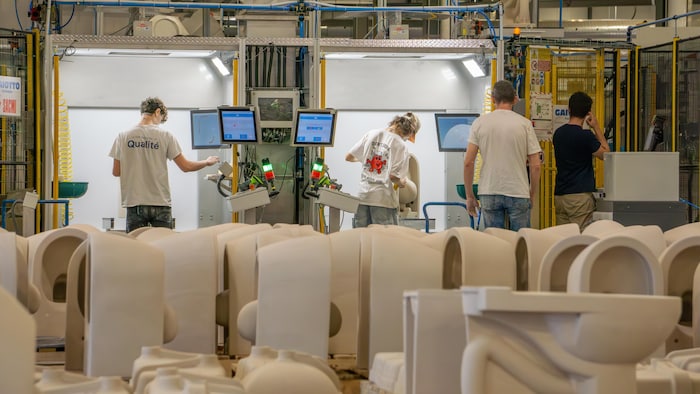 Des travailleurs vérifient la qualité des pièces en céramique.