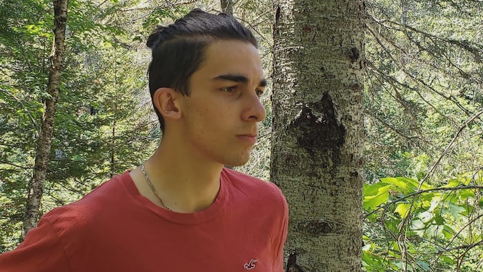 Dylan Samuel-Francoeur debout dans la forêt.