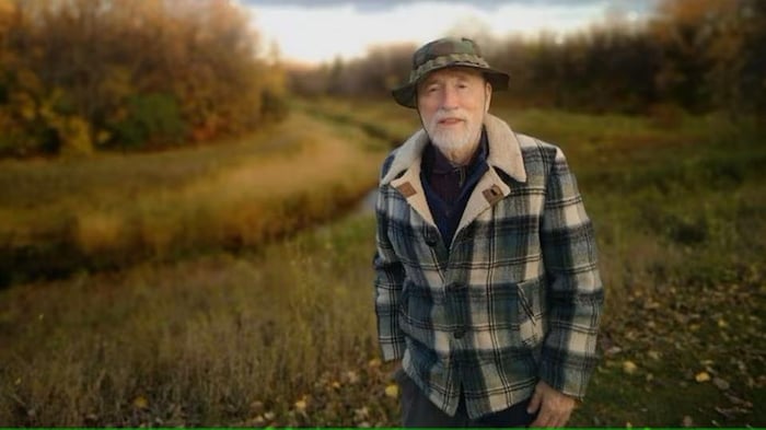 Earl Moberg, debout dans un espace vert en automne.