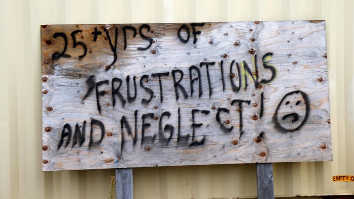 Un panneau avec l'inscription : plus de 25 ans de frustrations et de négligences.