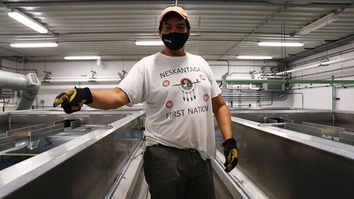 Un homme montre un système de traitement des eaux dans une usine.