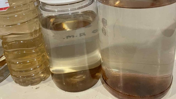 Des récipients contenant de l’eau avec des résidus bruns