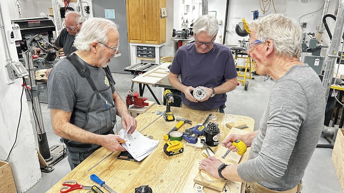 Des hommes dans un atelier d'ébénisterie. 