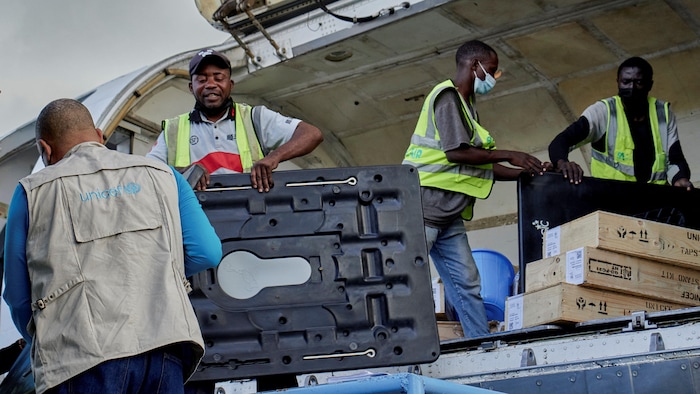 Des hommes déchargent du matériel médical d'un avion.