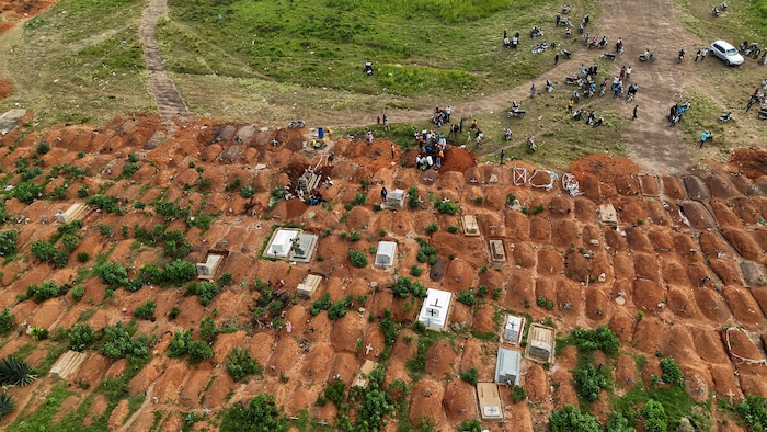 Vue aérienne d'un cimetière et de dizaines de sépultures en terre.