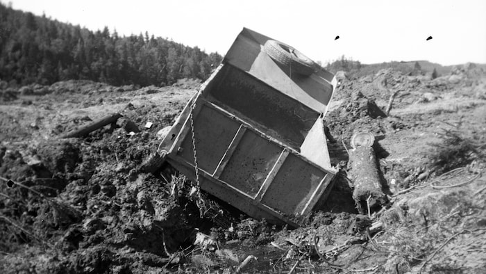 Un camion benne se retrouve dans un fâcheuse position après avoir été emporté par un glissement de terrain.