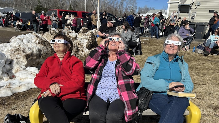 Trois femmes assisses avec des lunettes de protection sur les lieux. 