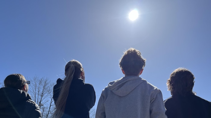 Des jeunes regardent l'éclipse solaire.