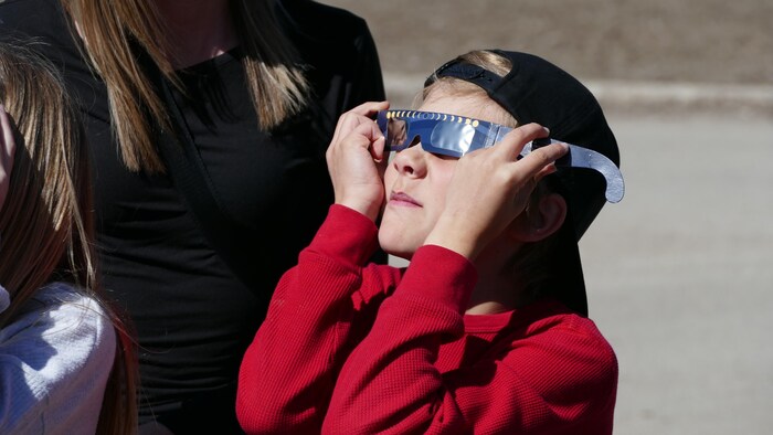 Un enfant observe l'éclipse solaire partielle au Centre des sciences de la Saskatchewan, à Regina, le 8 avril 2024.