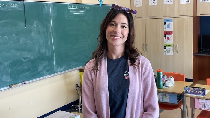 Marie-Michèle Servant pose dans une classe avec des lunettes protectrices sur la tête.