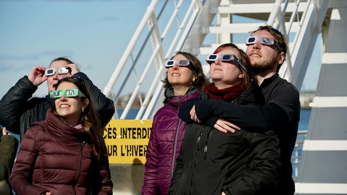 Des Rimouskois se sont réunis sur la promenade de la mer pour observer l'éclipse.              