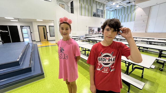 Deux enfants debout dans une nouvelle école. 