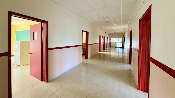 Un couloir de l'école avec des portes de classes ouvertes.
