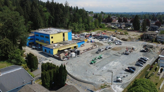 Un bâtiment en construction avec une forêt autour.