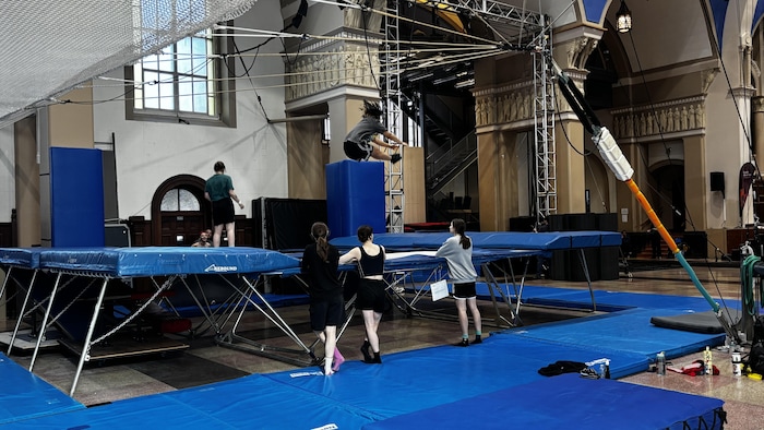 Des athlètes s'entraînent sur des trampolines.