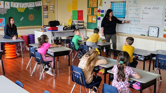 Une enseignante debout au tableau parle à ses élèves dans une salle de classe à l'école des Grands-Vents, le 19 mai 2022.