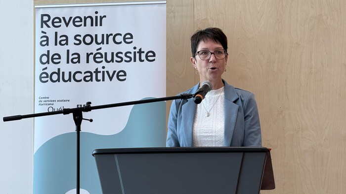 Nancy Létourneau, debout derrière un lutrin, parle dans un micro.