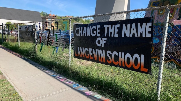 Une affiche, sur une clôture, demandant le changement de nom de l'école Langevin en Alberta.