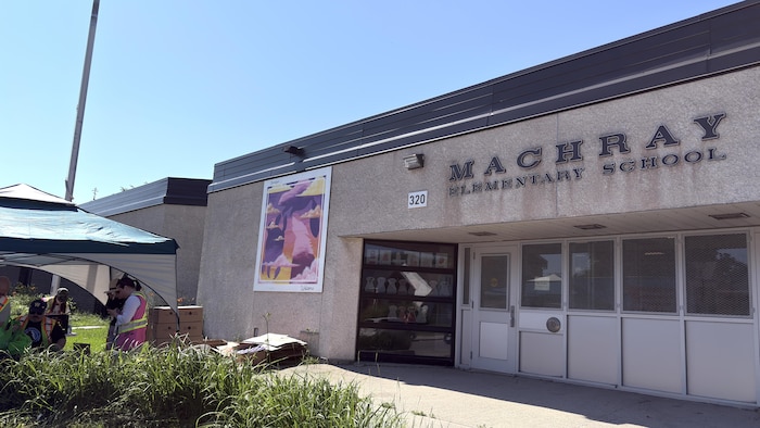 La façade de l'école Machray, à Winnipeg, et la tente de la banque alimentaire.
