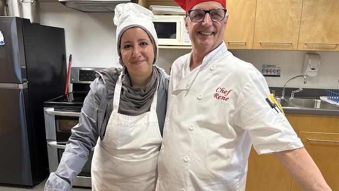 Khadija Maher et le chef cuisinier René Mailloux dans la cuisine de l'école.