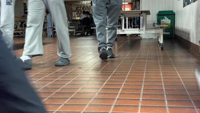 Des élèves marchent dans la cafétéria d'une école.