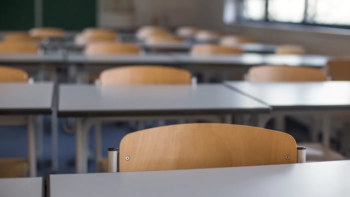 Des pupitres dans une salle de classe.