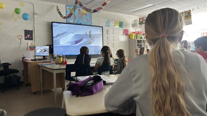 Des élèves visionnent les Jeux olympiques avec beaucoup d'attention.