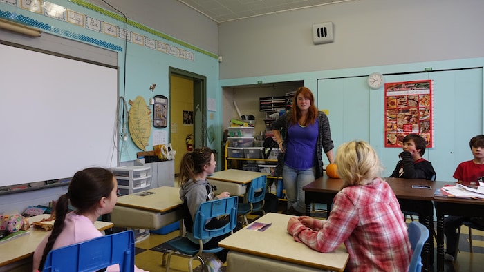 Une enseignante devant sa classe de cinquième et de sixième année. 