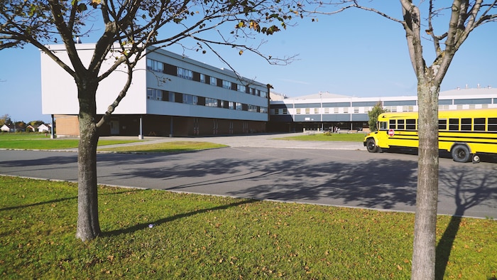 Le bâtiment de l'école et un autobus scolaire.