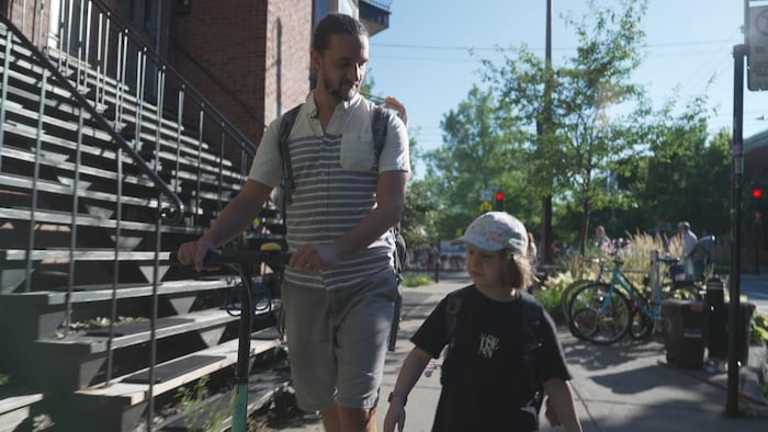 Un père et son enfant marchent près d'une école primaire.