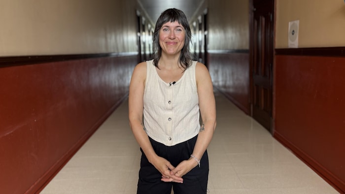 Une militante pour une école publique plus équitable pose dans le corridor d'une ancienne école.