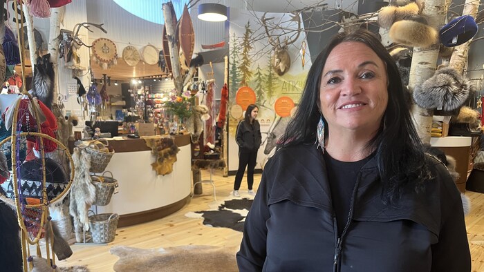 Josée Leblanc sourit à la caméra, au milieu de sa boutique d'artisanat Atikuss.