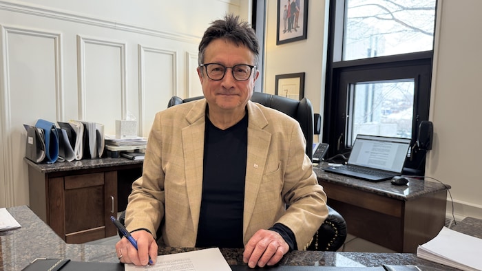 Eddy Métivier assis derrière un bureau.