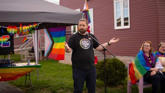 Eddy St. Coeur pose pour la photo vêtu d'un t-shirt de Fierté Saint-Jean.