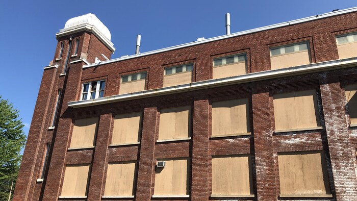 Les fenêtres du bâtiment sont placardées.
