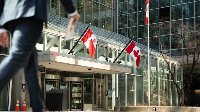 Un fonctionnaire marche devant un édifice fédéral du centre-ville d'Ottawa.