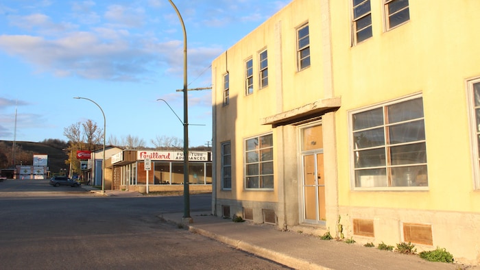 Le rue principale d'un village au Manitoba l'automne. Deux immeubles commerciaux vacants. 